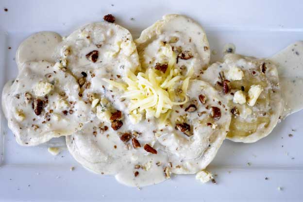 Ravioli stuffed with blue cheese and walnuts with a 4-cheese sauce 