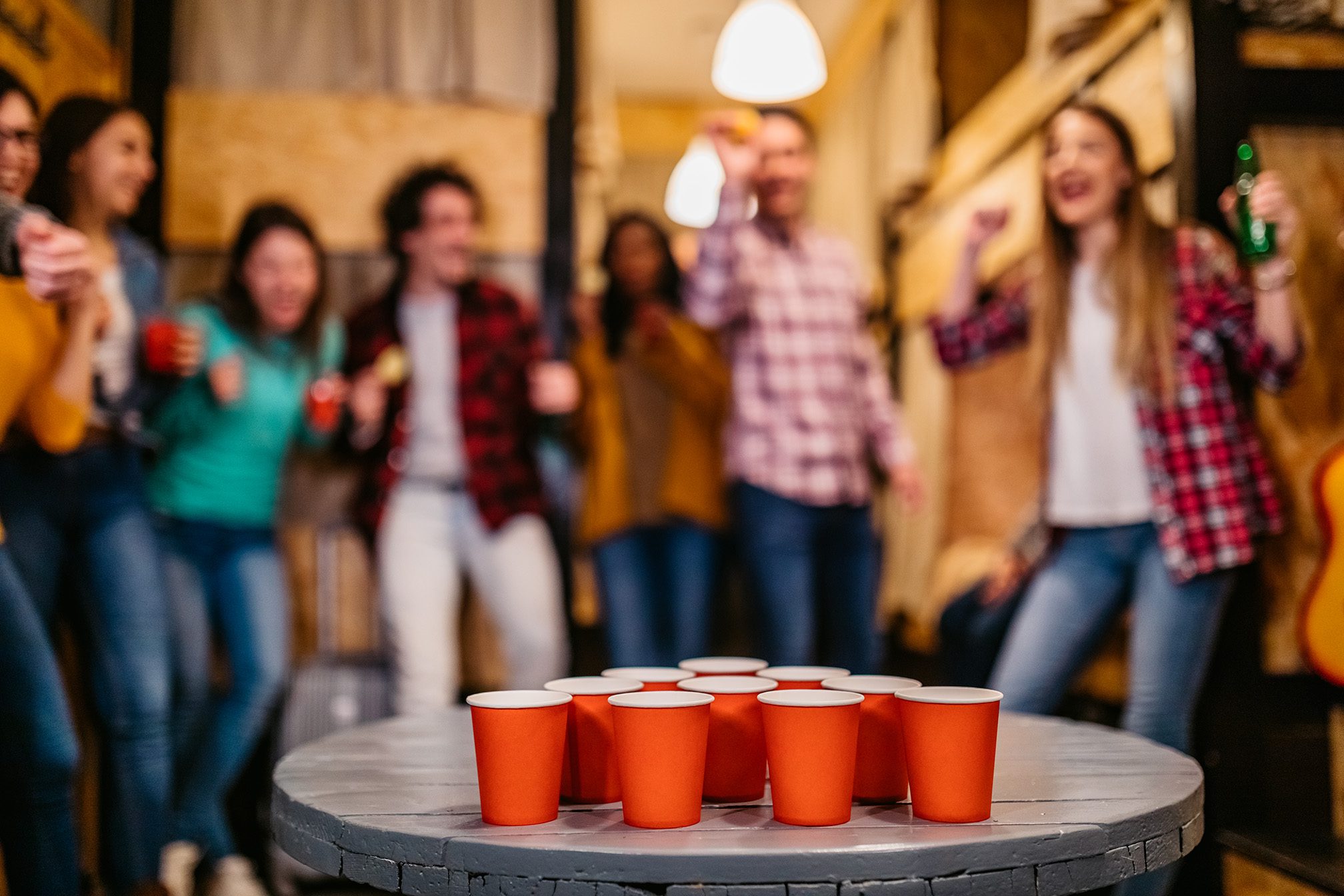 Young people playing beer pong in hostel