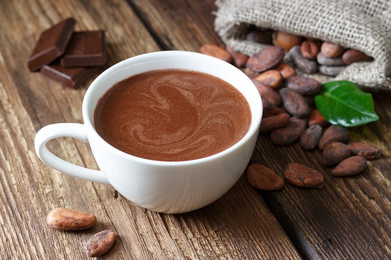 Hot chocolate in the cup on the wooden table.